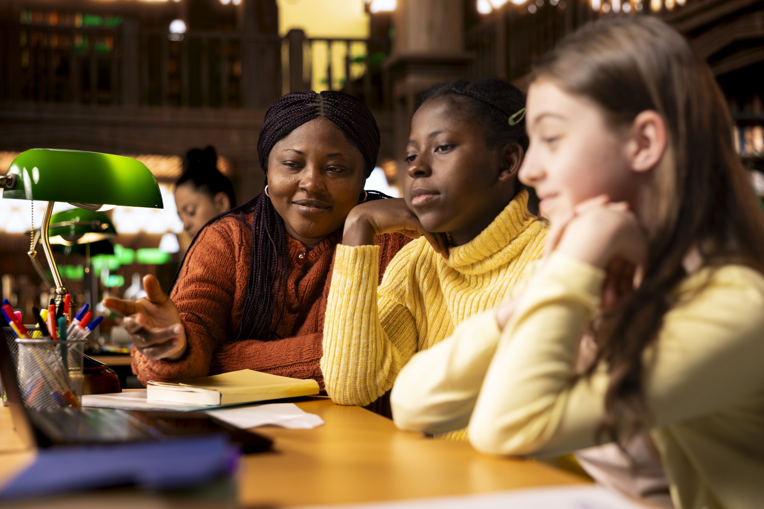 african american professor mentoring her teen girls students with an assessment